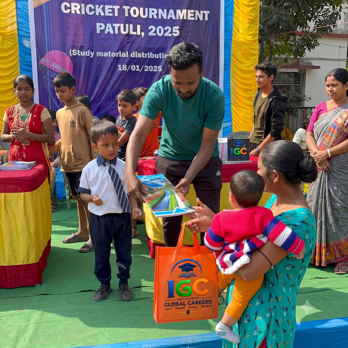 IGC volunteer handing notebooks to a young girl at the cricket tournament